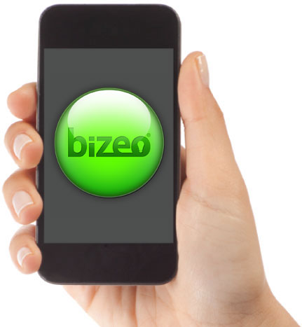 Hand holding an iPhone showing green Bizeo monitor